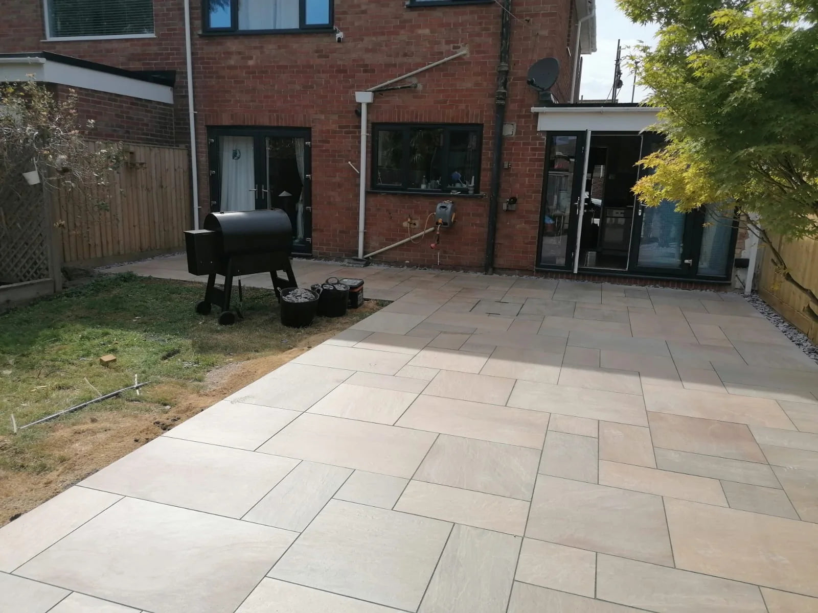 Completed mixed-size paved patio across a rear garden
